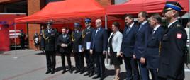Awansowani strażacy oraz zaproszeni goście na tle budynku komendy