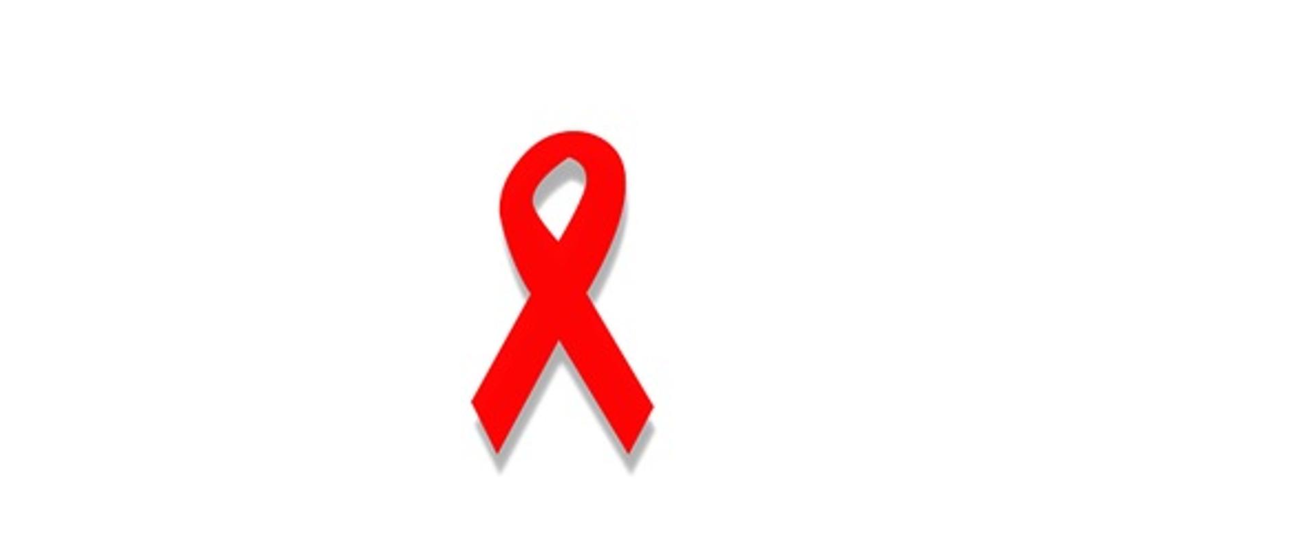 Na białym tle znajduje się czerwona wstążka, która jest symbolem solidarności z osobami żyjącymi z HIV i AIDS, ich rodzinami i przyjaciółmi.