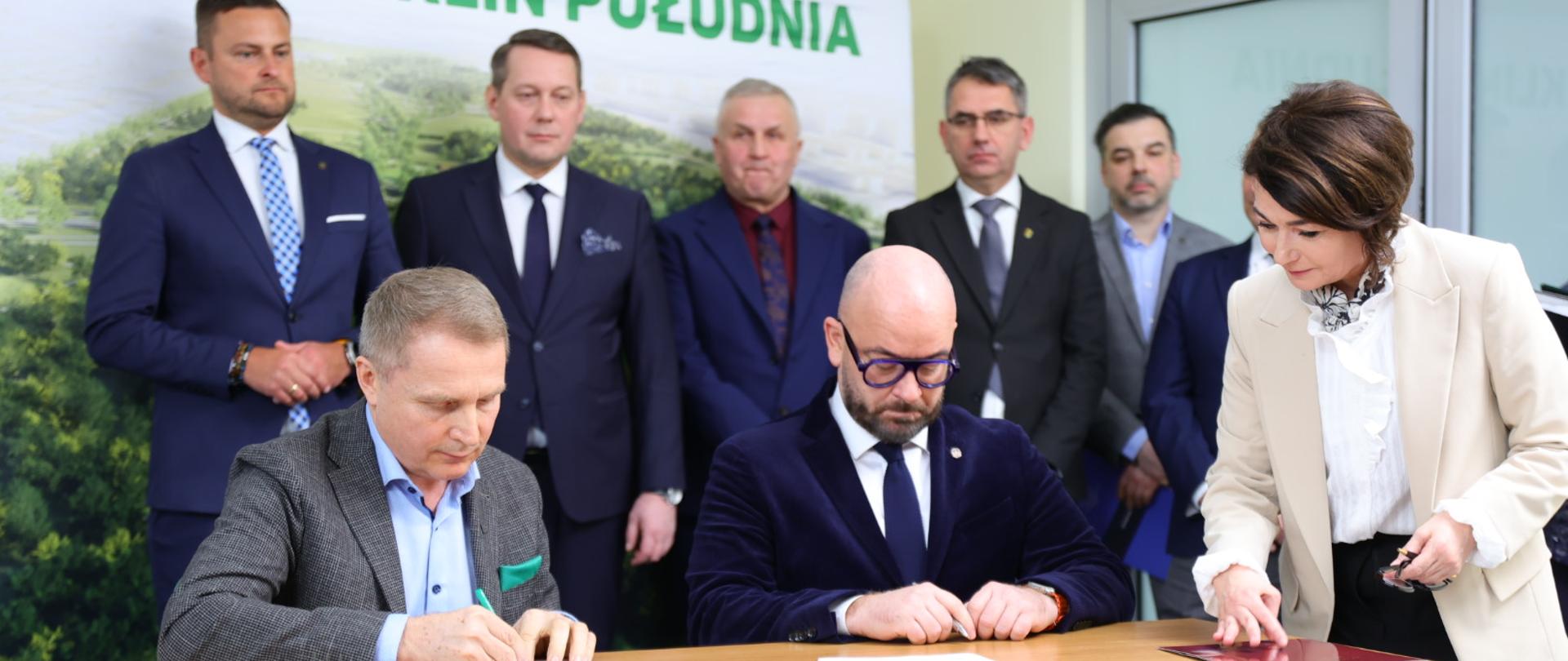 Dyrektor Generalny KOWR Henryk Smolarz z lewej i Prezydent Wrocławia Jacek Sutryk z prawej podpisują w obecności notariusza akt notarialny nieodpłatnego przekazania 65 ha gruntów z Zasobu Własności Rolnej Skarbu Państwa, na których powstanie tzw. "Zielony Klin Południa"