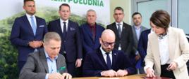 Dyrektor Generalny KOWR Henryk Smolarz z lewej i Prezydent Wrocławia Jacek Sutryk z prawej podpisują w obecności notariusza akt notarialny nieodpłatnego przekazania 65 ha gruntów z Zasobu Własności Rolnej Skarbu Państwa, na których powstanie tzw. "Zielony Klin Południa"