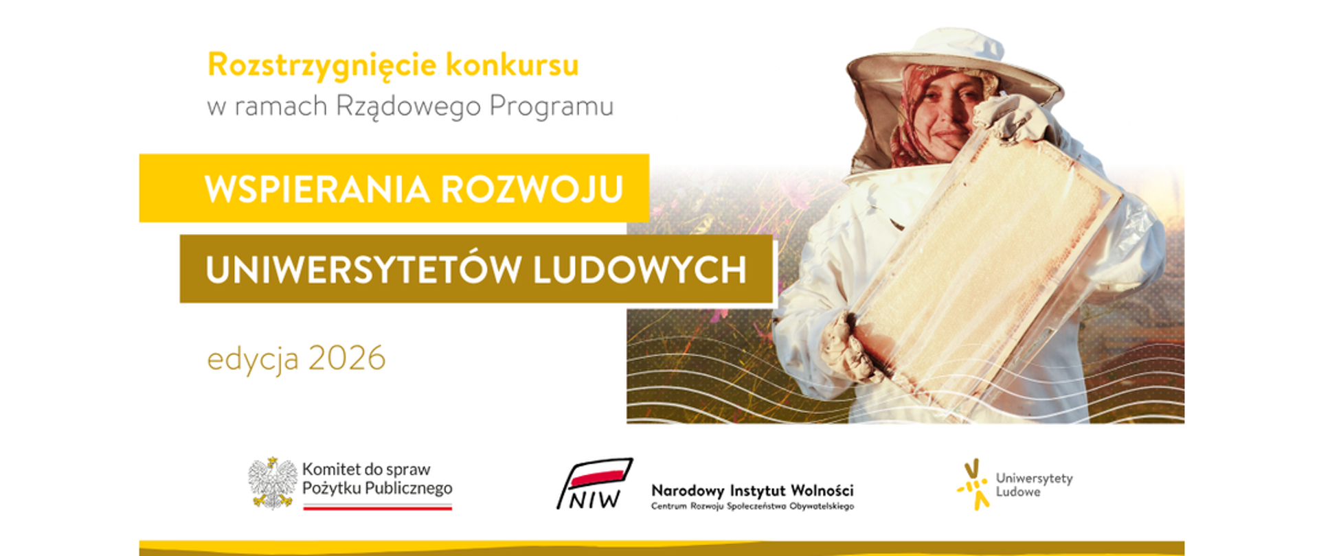 Grafika nagłówkowa do artykułu. W lewej części grafiki tytuł: Rozstrzygnięcie konkursu w ramach Rządowego Programu Wspierania Rozwoju Uniwersytetów Ludowych edycja 2026. W prawej części grafiki symboliczne zdjęcie – kobieta w stroju ochronnym pszczelarza trzyma w dłoniach drewnianą ramkę z plastrem miodu. Ma na głowie kapelusz z siatką ochronną, za nią rozmyte tło w ciepłym świetle. Poniżej, na dole grafiki widoczne są loga: Komitet do spraw Pożytku Publicznego, Narodowy Instytutu Wolności oraz Uniwersytety Ludowe. 