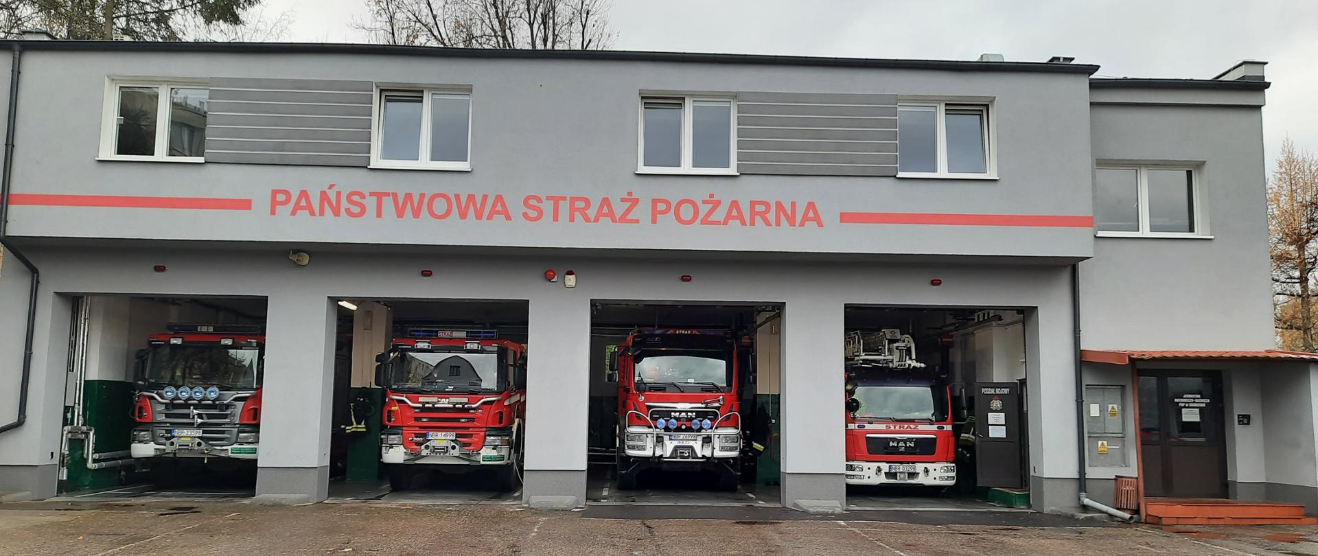 widok strażnicy JRG, otwarte bramy garażu bojowego a w nim czerwone sachody