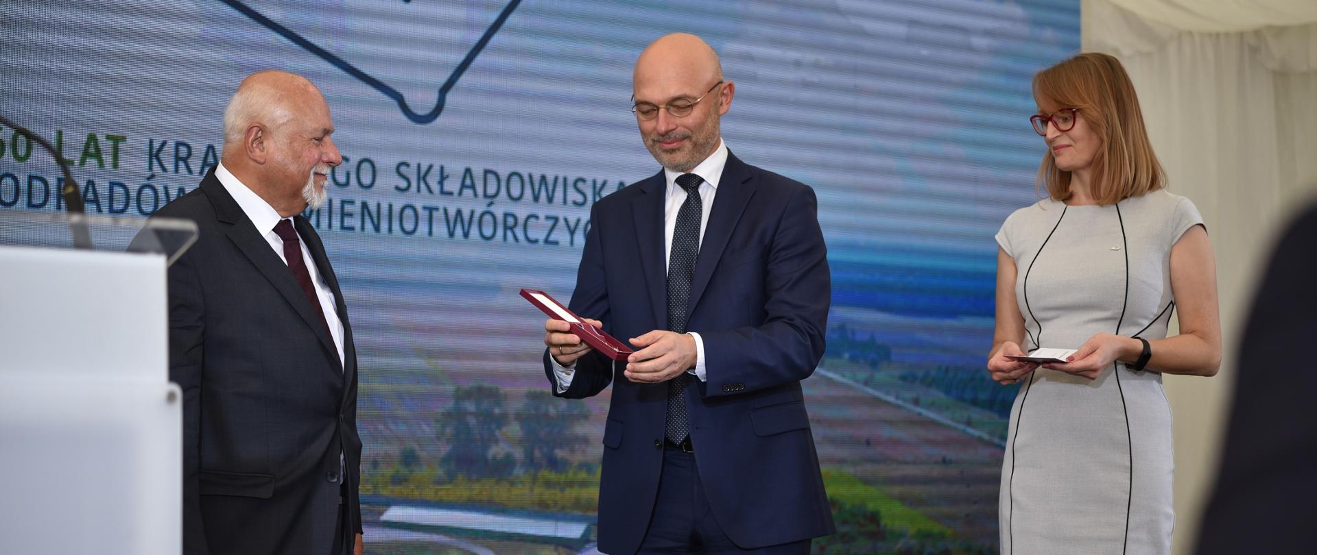 Minister Klimatu i Środowiska Michał Kurtyki wręcza nadany przez Prezydenta Rzeczypospolitej Polskiej Andrzeja Dudę – Złoty Krzyż Zasługi emerytowanemu Dyrektorowi Zakładu Unieszkodliwiania Odpadów Promieniotwórczych Andrzejowi Cholerzyńskiemu. 