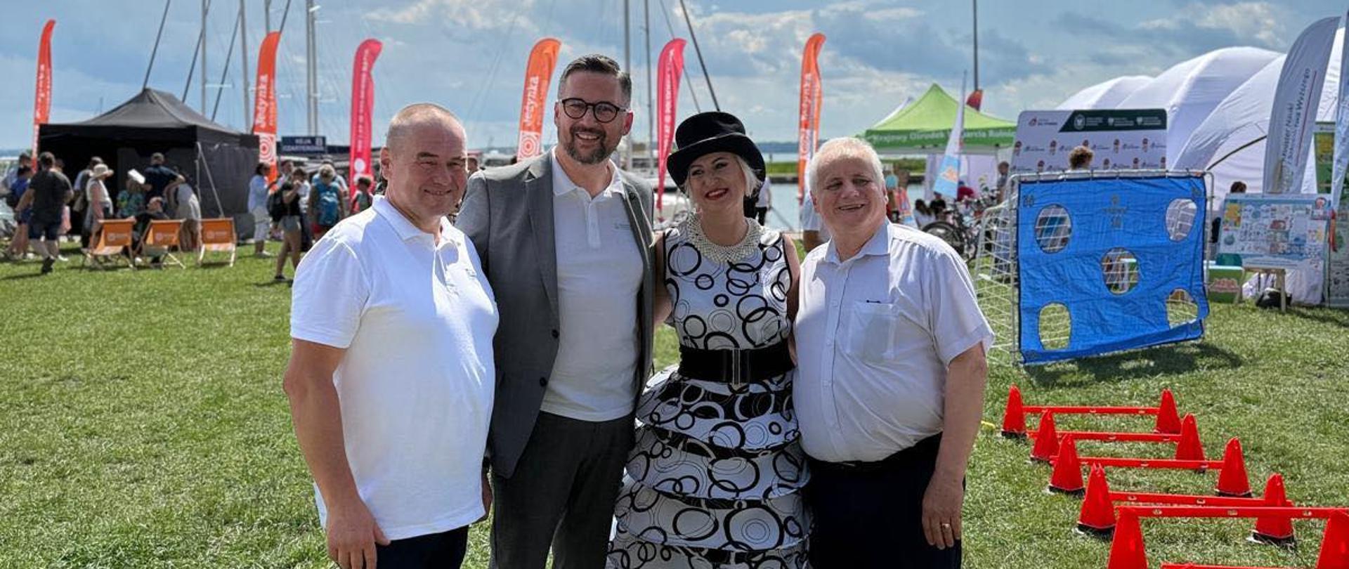 Trzy osoby stoją na polu uśmiechając się do zdjęcia. 