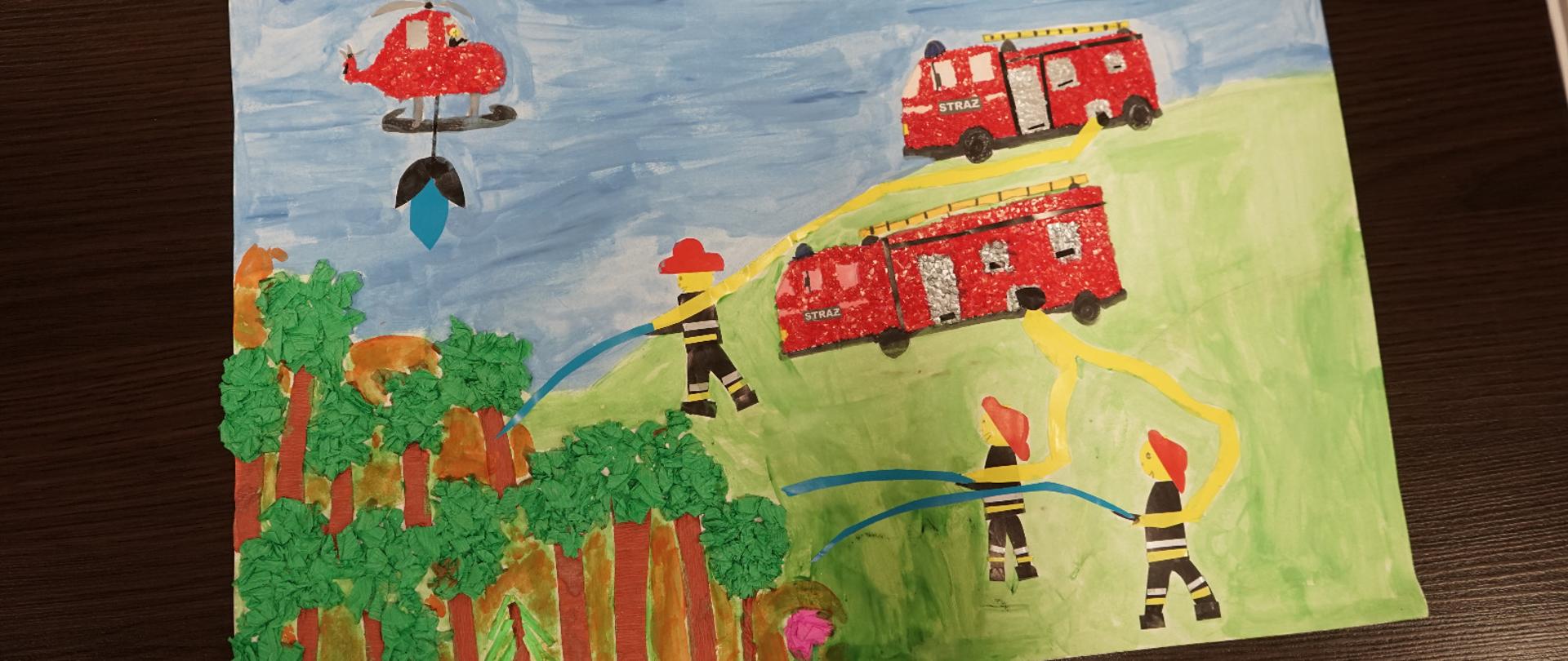 Zdjęcie robione dla obrazka wykonanego przez dzieci. Na obrazku strażacy walczą z pożarem. Na zielonej łącze stoją dwa samochody strażackie i trzech strażaków. Na niebieskim niebie leci śmigłowiec strażacki.