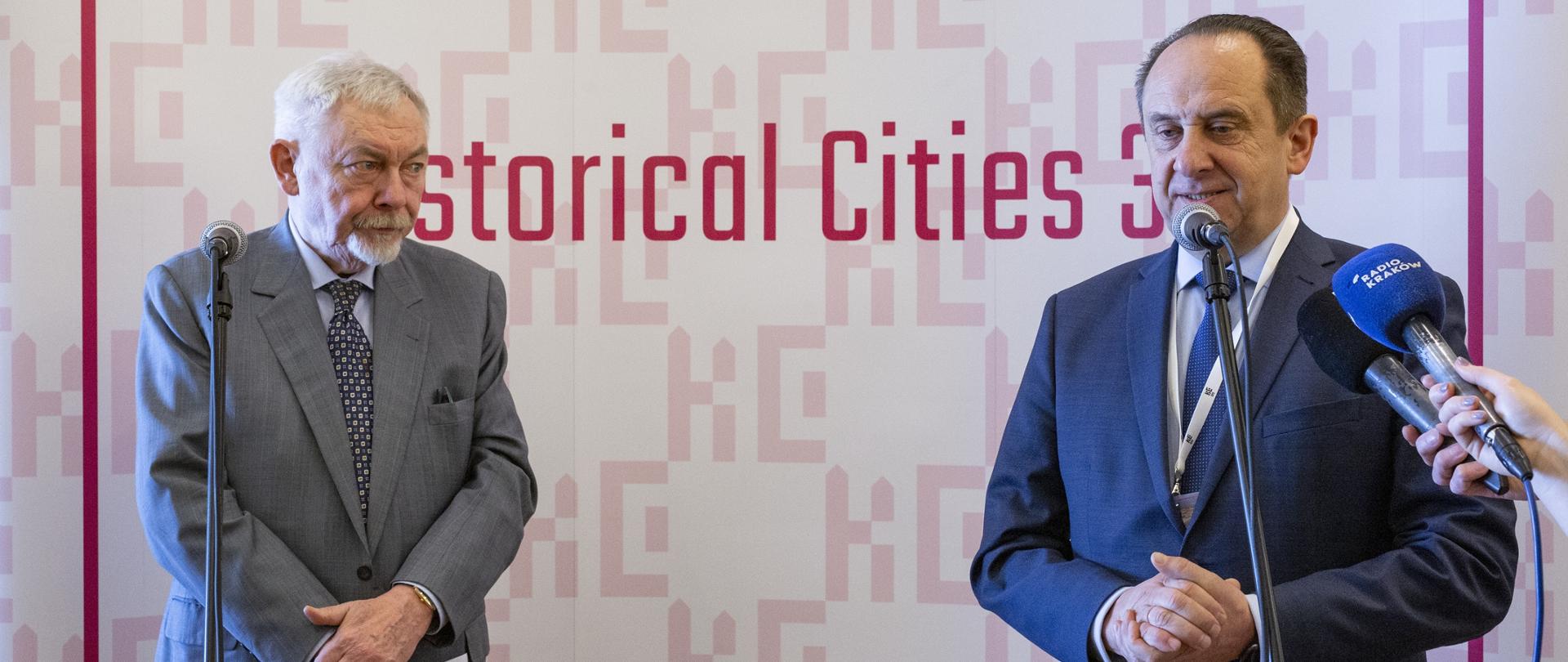 Wiceminister Andrzej Gut-Mostowy otworzył konferencję Miasta Historyczne 3.0. Na zdjęciu minister przemawia na scenie do mikrofonu.