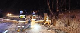 Strażacy usuwają powalone drzewo z drogi