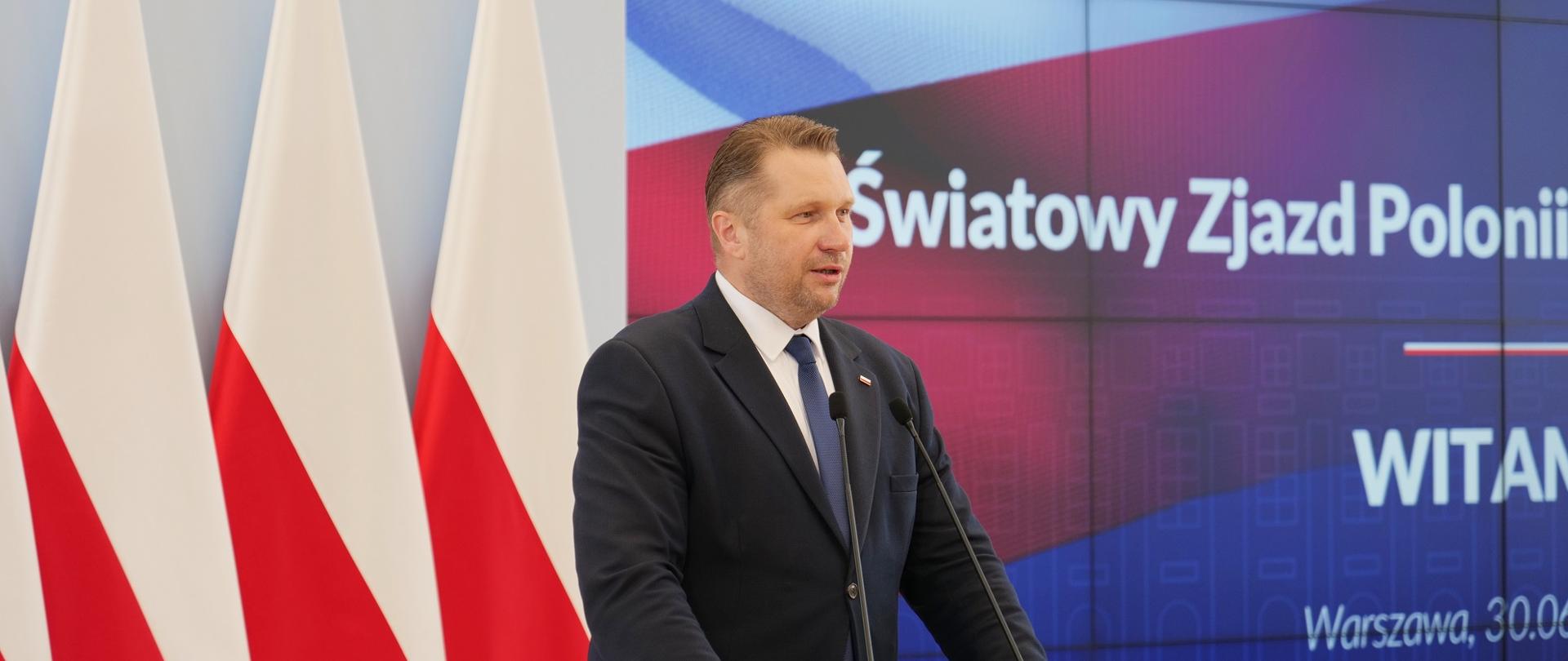 Przy mównicy minister Czarnek i mówi do mikrofonu, za nim polskie flagi, obok na wielkim ekranie napis VI Światowy Zjazd Polonii i Polaków za Granicą.