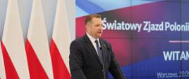 Przy mównicy minister Czarnek i mówi do mikrofonu, za nim polskie flagi, obok na wielkim ekranie napis VI Światowy Zjazd Polonii i Polaków za Granicą.