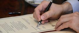 Wojewoda Małopolski podpisuje list intencyjny.. Widoczne tylko dłonie i list intencyjny.