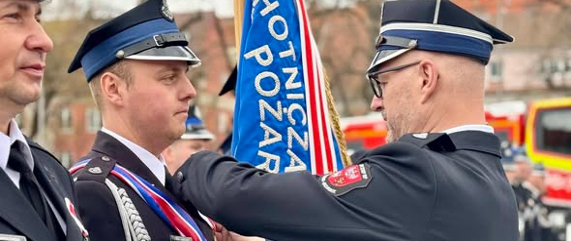 Wojewoda Radosław Król wręcza odznaczenie.