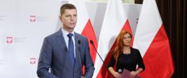Minister Edukacji Narodowej Dariusz Piontkowski przemawia za mównicą w tle polskie flagi