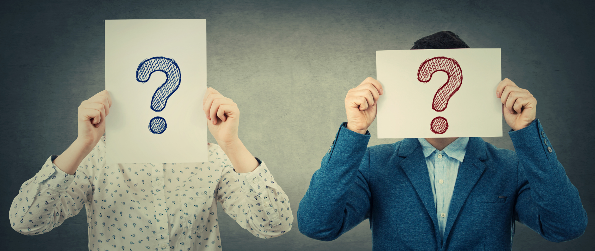 Dwie osoby z twarzami zasłoniętymi kartkami ze znakami zapytania