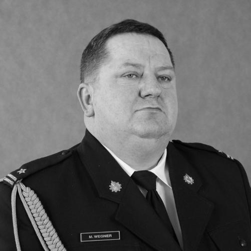 czarno-białe zdjęcie strażaka w mundurze w białej koszuli z krawatem
