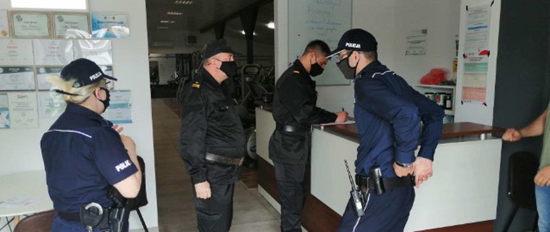 Zdjęcie przedstawia funkcjonariuszy Komendy Powiatowej Państwowej Straży Pożarnej w Radziejowie i Komendy Powiatowej Policji w Radziejowie przeprowadzających kontrolę w jednym z obiektów sportowych na terenie powiatu radziejowskiego.