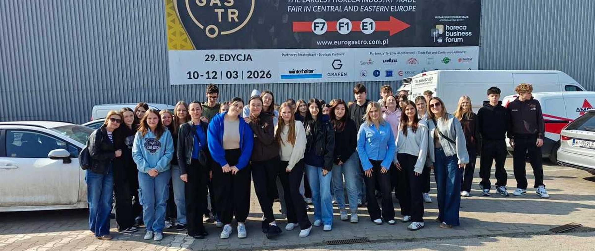 Na zdjęciu znajduje się grupa osób uczestniczących w EuroGastro 2026, czyli międzynarodowych targach rozwiązań dla branży HoReCa (hotelarsko-gastronomicznej), które odbyły się w centrum Ptak Warsaw Expo.
To wydarzenie jest skierowane do profesjonalistów z branży, a jego celem jest integracja sektora, prezentacja nowoczesnych technologii oraz nawiązywanie kontaktów biznesowych. 