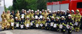 Zdjęcie grupowe - wszyscy uczestnicy szkolenia OSP na tle samochodu pożarniczego.