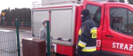 Na zdjęciu samochód strażacki, strażak OSP podczas transportu do szczepienia 