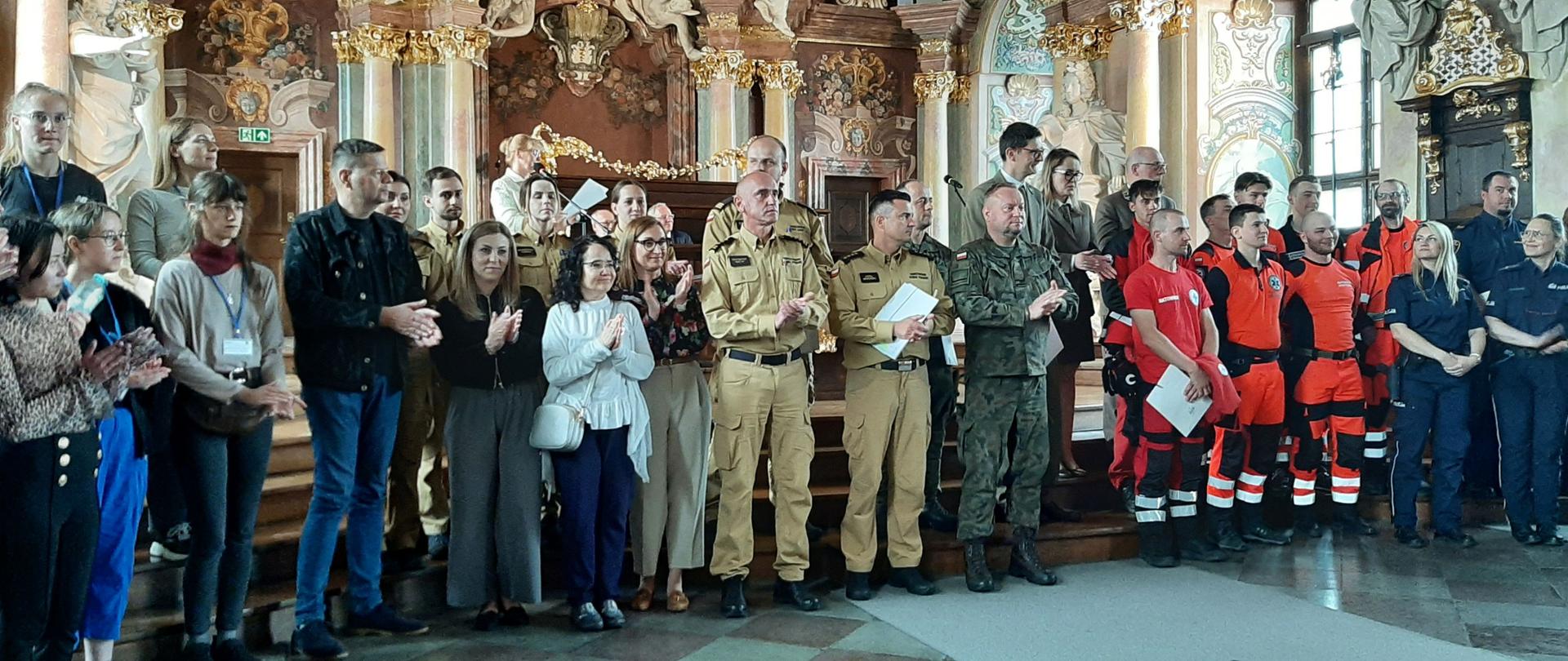 Osoby stojące w szeregu w Auli Leopoldina na Uniwersytecie Wrocławskim