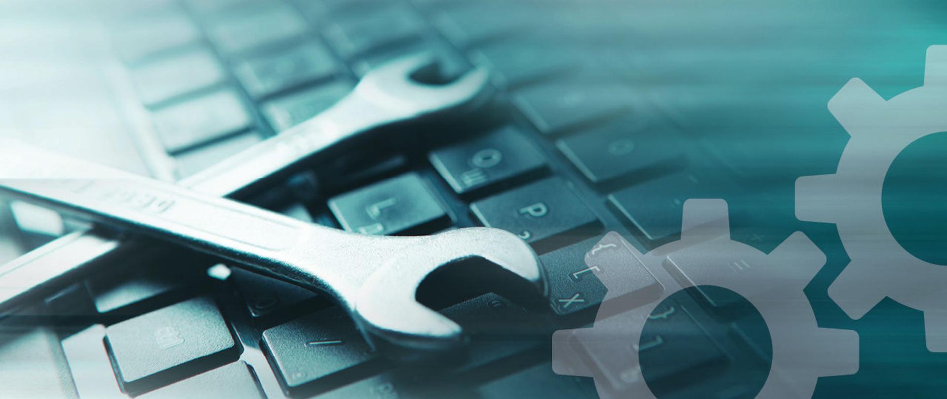 klucze do naprawy leżące na klawiaturze laptopa