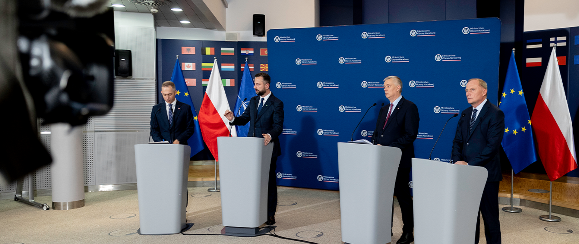 Minister Obrony Narodowej Władysław Kosiniak-Kamysz, Minister Spraw Wewnętrznych i Administracji Tomasz Siemoniak oraz wiceminister Cezary Tomczyk i wiceminister Czesław Mroczek stoją na tle błękitnej ścianki z logotypem Ministerstwa Obrony Narodowej w otoczeniu flag Polski, Unii Europejskiej i Paktu Północnoatlantyckiego.