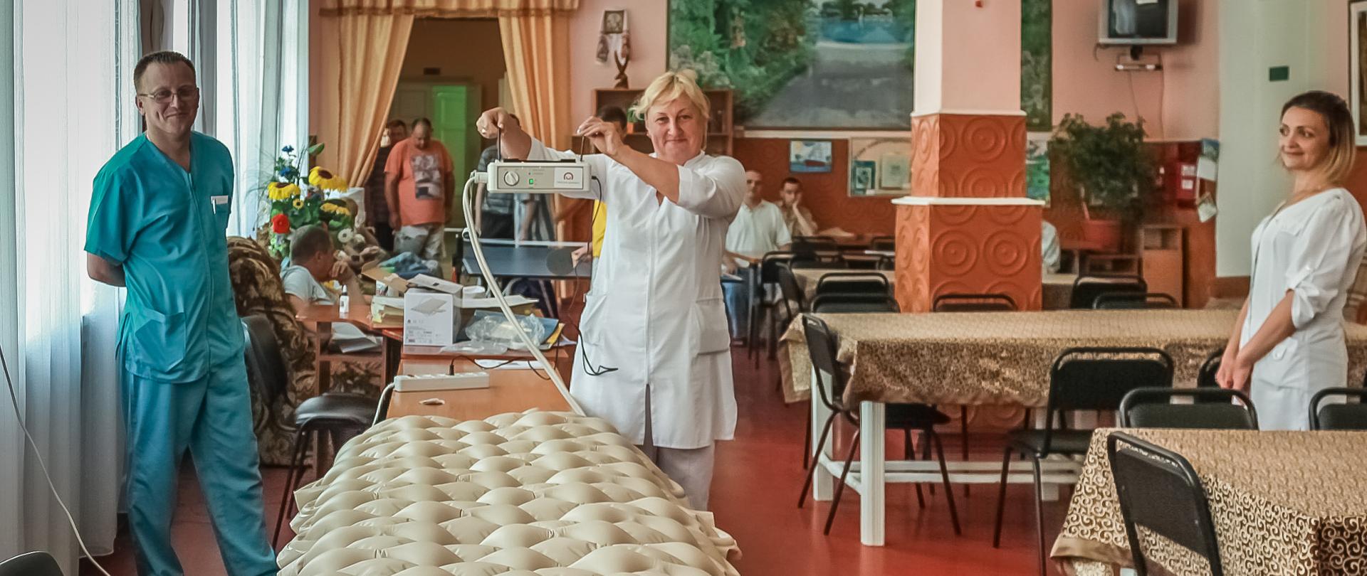 kadra medyczna ośrodka prezentuje materac przeciodleżynowy z naklejką Polskiej pomocy
