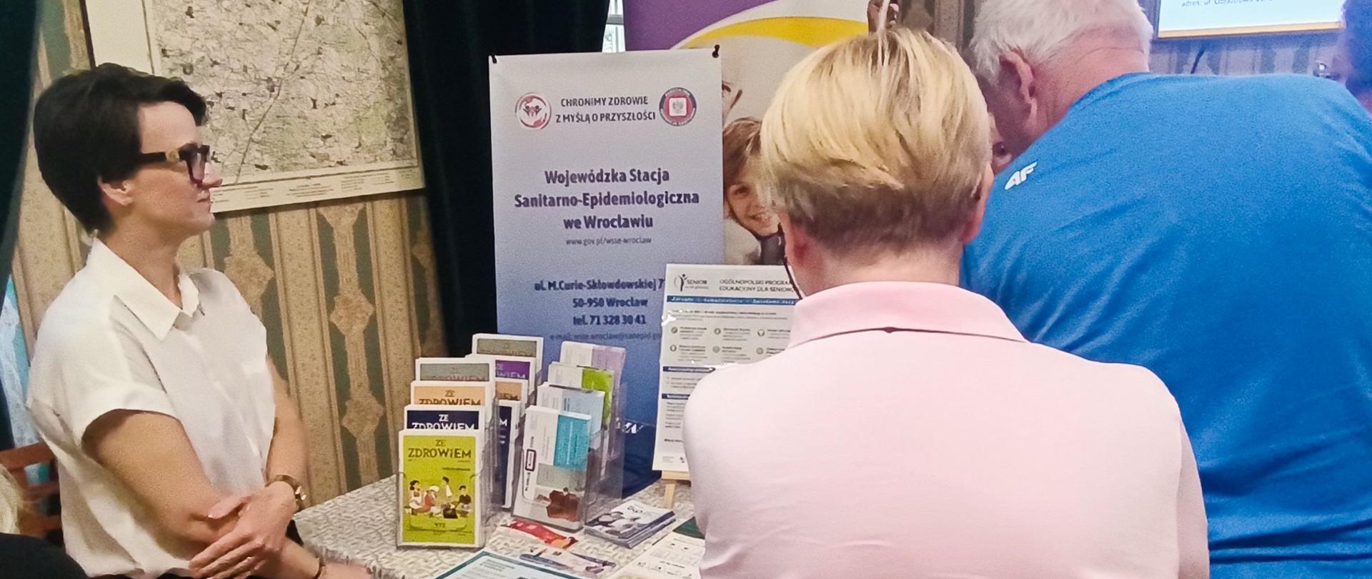 Osoba prezentująca seniorom materiały edukacyjne dotyczące zdrowego trybu życia
