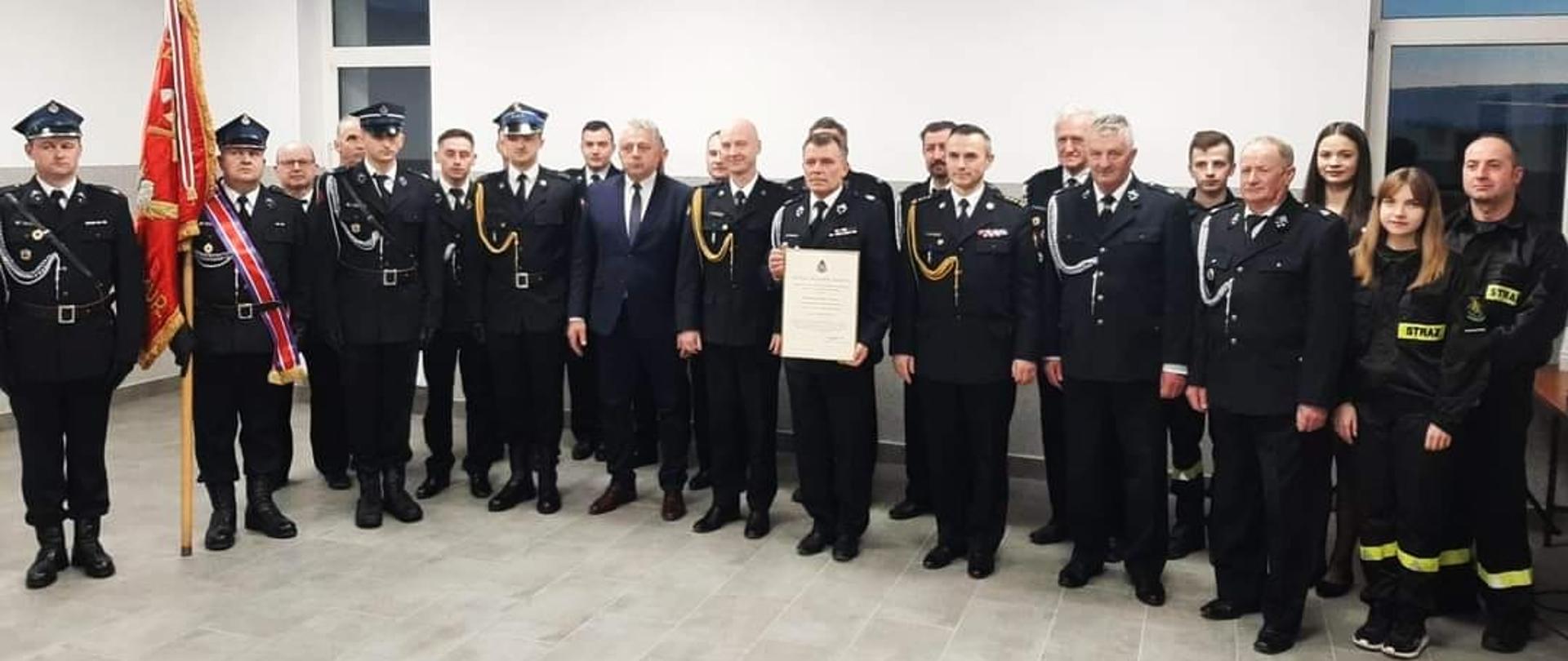 Na zdjęciu zaproszeni goście na uroczystość wręczenia OSP Opatkowice Murowane do krajowego systemu ratowniczo-gaśniczego: zastępca świętokrzyskiego komendanta wojewódzkiego Państwowej Straży Pożarnej w Kielcach st. bryg. Artur Brachowicz, komendant powiatowy Państwowej Straży Pożarnej w Jędrzejowie mł. bryg. Mariusz Stolarczyk, wójt gminy Imielno Zbigniew Huk oraz przedstawiciele jednostki OSP Opatkowice Murowane.