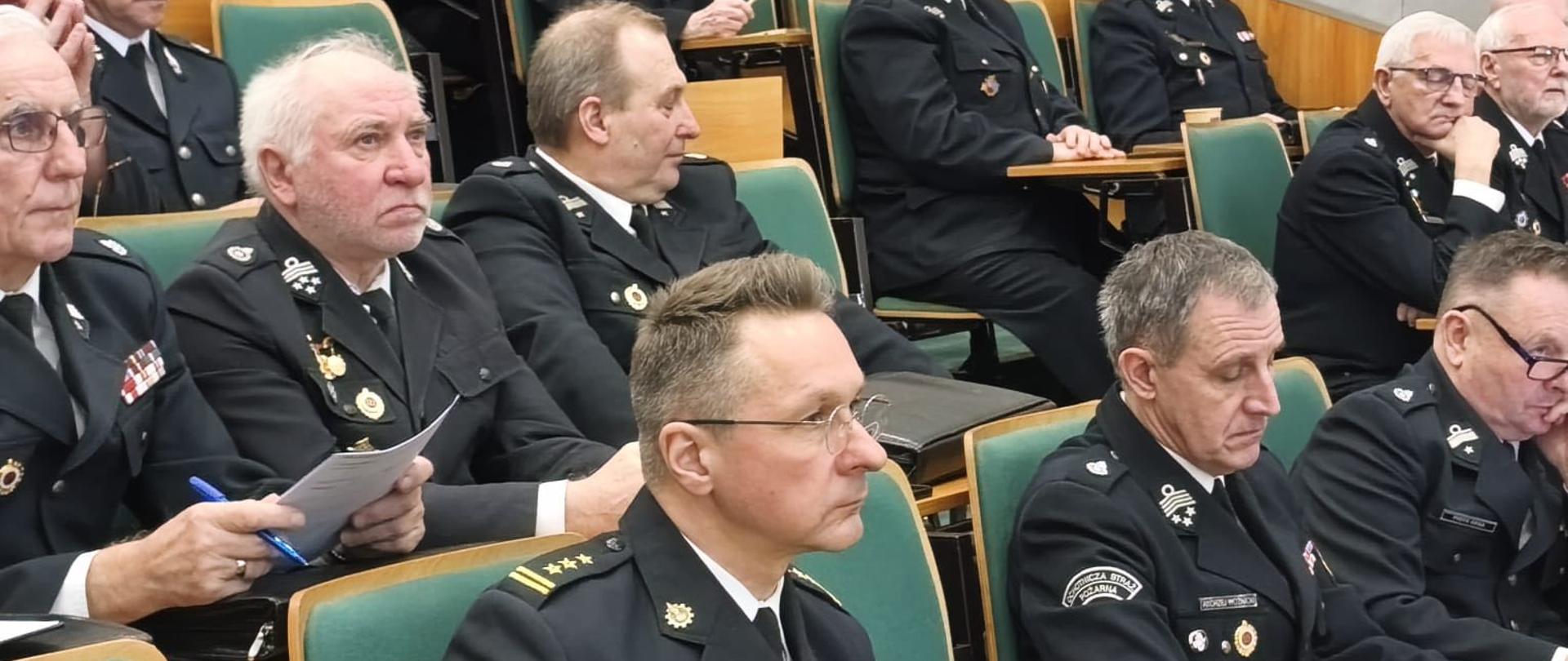 Na zdjęciu strażacy OSP ubrani w umundurowanie wyjściowe zajmują miejsca w sali Szkoły Aspirantów PSP w Poznaniu i uczestniczą w zebraniu, odprawie, podsumowującą 2025 rok.