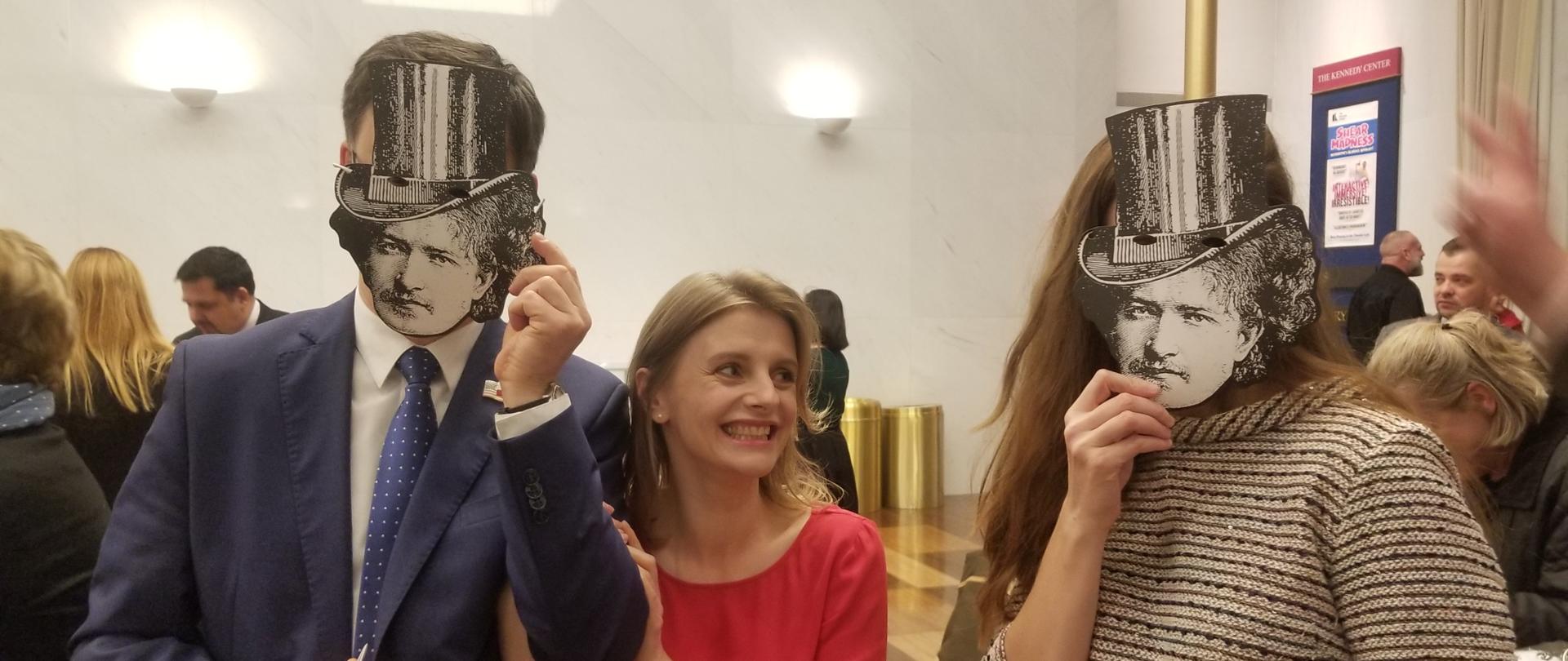 Troje widzów na przedstawieniu "3 Paderwskis". Dwoje z nich w maskach z wizerunkiem Paderewskiego