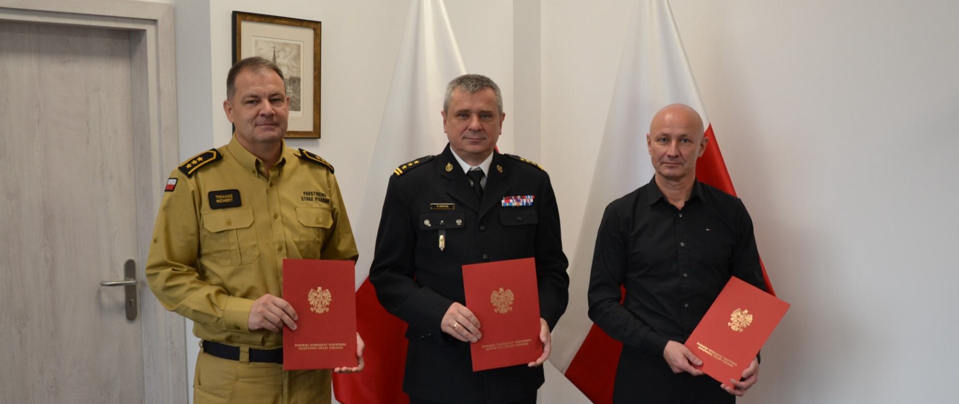 Pomorski komendant wojewódzki Państwowej Straży Pożarnej oraz przedstawiciele związków zawodowych trzymają podpisane porozumienia. 