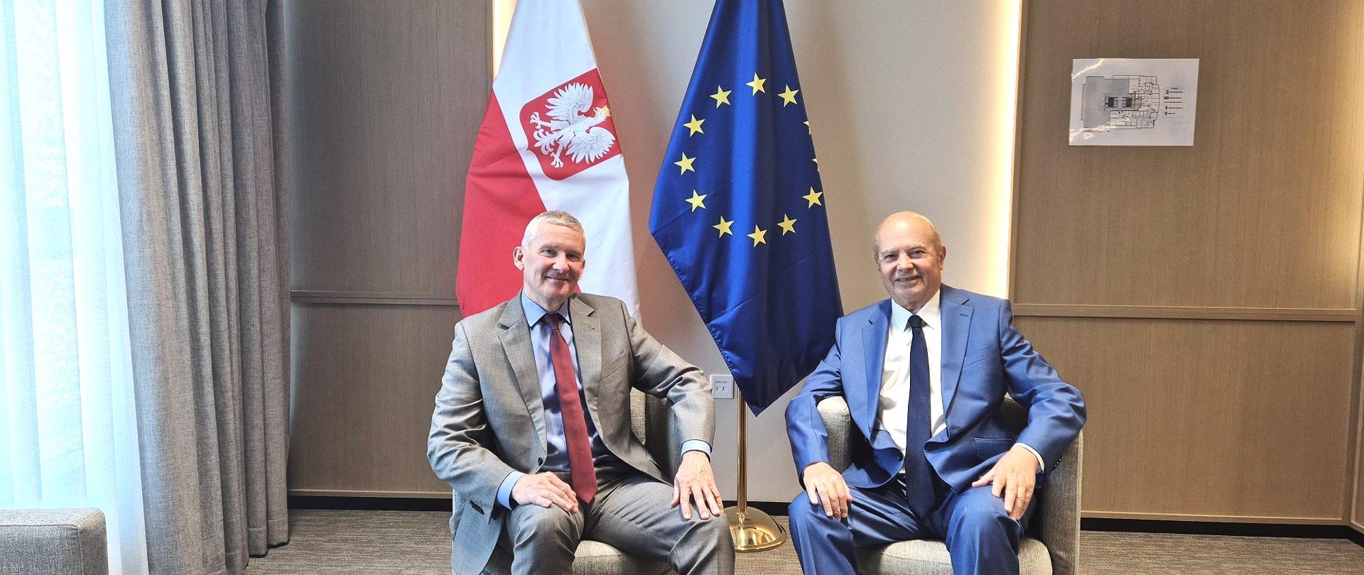 Na zdjęciu szef placówki, Grzegorz Gawin, z dziennikarzem IRIS media siedzą w fotelach na tle flagi Polski i Unii Europejskiej