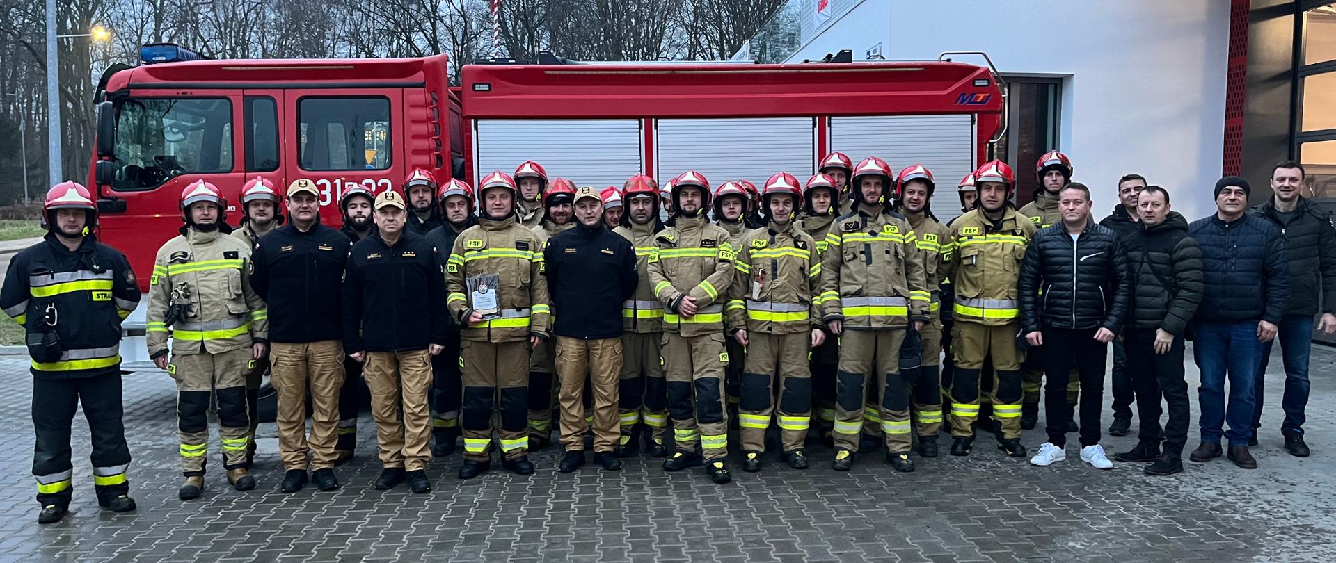 Zdjęcie grupowe funkcjonariuszy na JRG1 podczas zdania ostatniej służby mł. bryg. Arkadiusza Buaraka