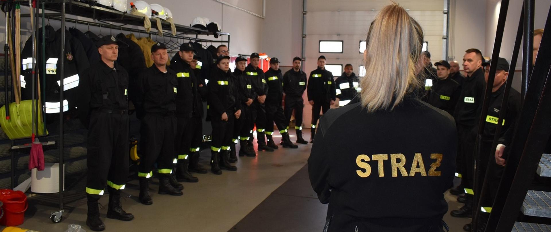 Zdjęcie przedstawia strażaków Ochotniczych Straży Pożarnych podczas przygotowania do ćwiczeń w komorze dymowej