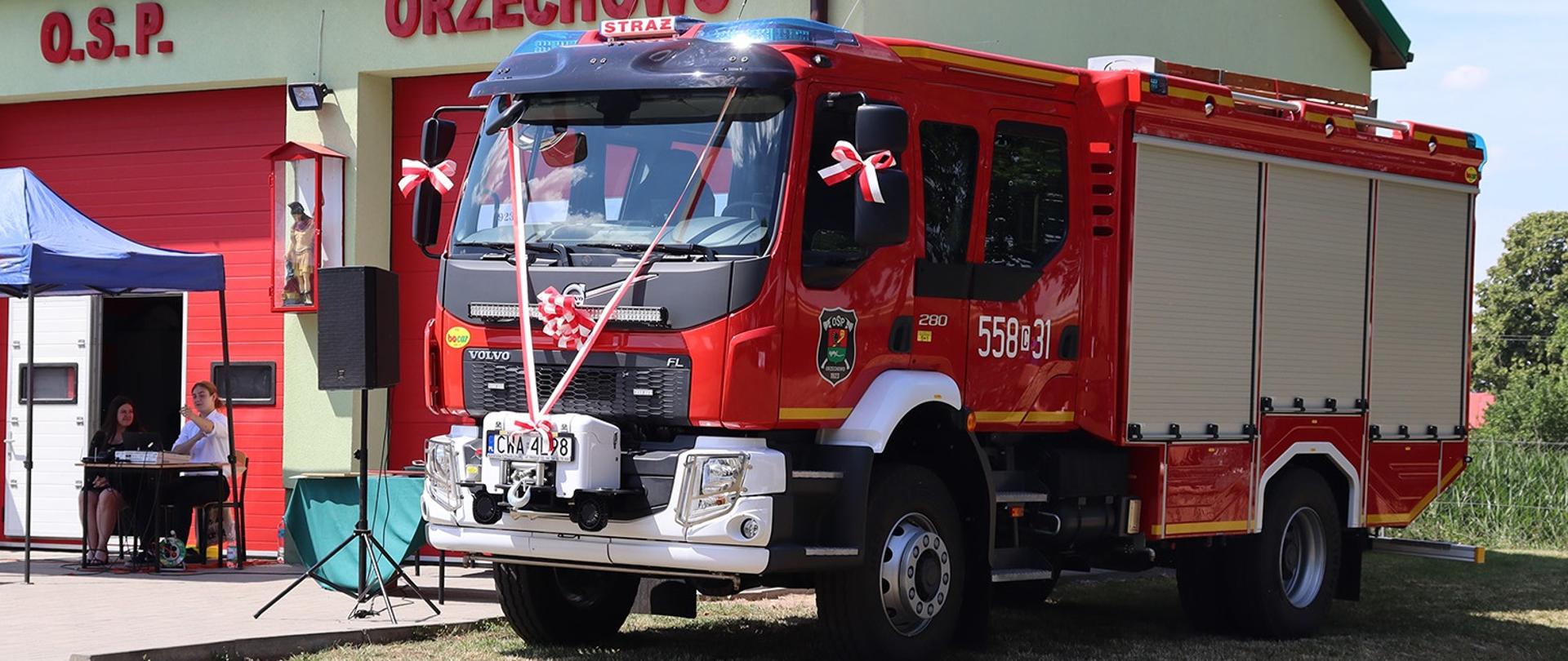 Samochód pożarniczy na tle remizy OSP Orzechowo.
