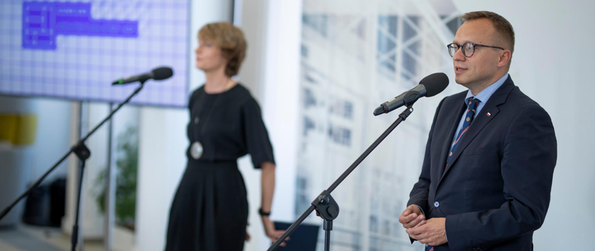 wiceminister Artur Soboń mówi do mikrofonu za nim widoczny napis finał konkursu