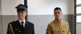 dwóch funkcjonariuszy państwowej straży pożarnej, jeden z nich ma na sobie mundur wyjściowy, drugi ubrany jest w mundur służbowy, zdjęcie wykonane w garażu komendy powiatowej państwowej straży pożarnej w sępólnie krajeńskim