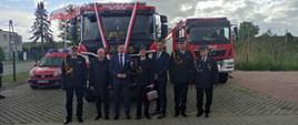 Na zdjęciu widzimy zaproszonych gości oraz gospodarzy, stojących na tle nowo przekazanego samochodu ratowniczo-gaśniczego