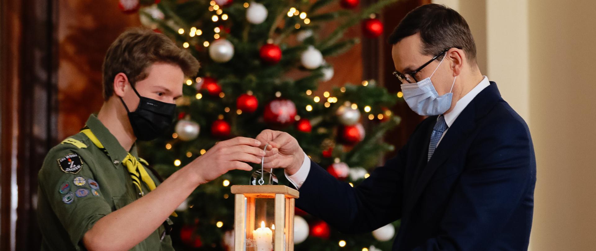 Premier Mateusz Morawiecki przyjmuje Betlejemskie Światło Pokoju od harcerzy.