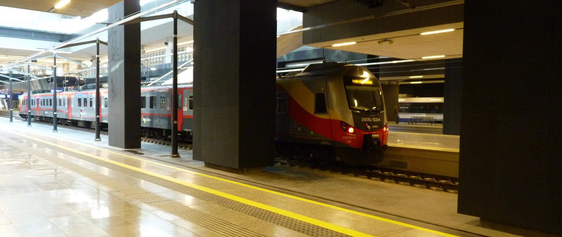 widoczne pomieszczenie, dworzec kolejowy, na peronie za kolumnami widoczny pociąg