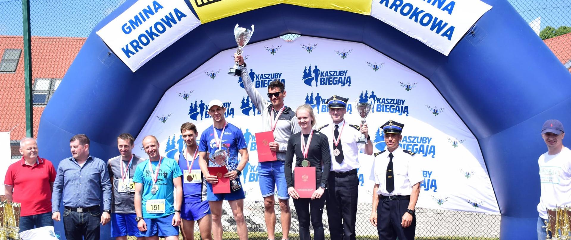 Zwycięzcy biegu (klasyfikacja mężczyzn - Państwowa Straż Pożarna) w obecności organizatorów biegu.