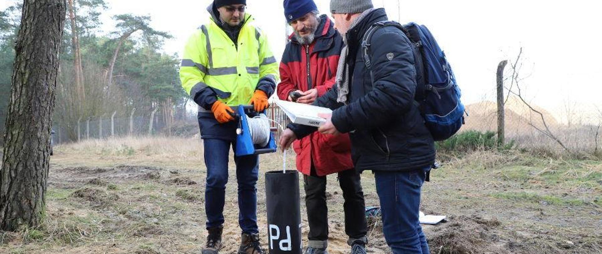 Wiercenie zakończone -= trzech mężczyzn stoi nad instalacją i sprawdza jej parametry