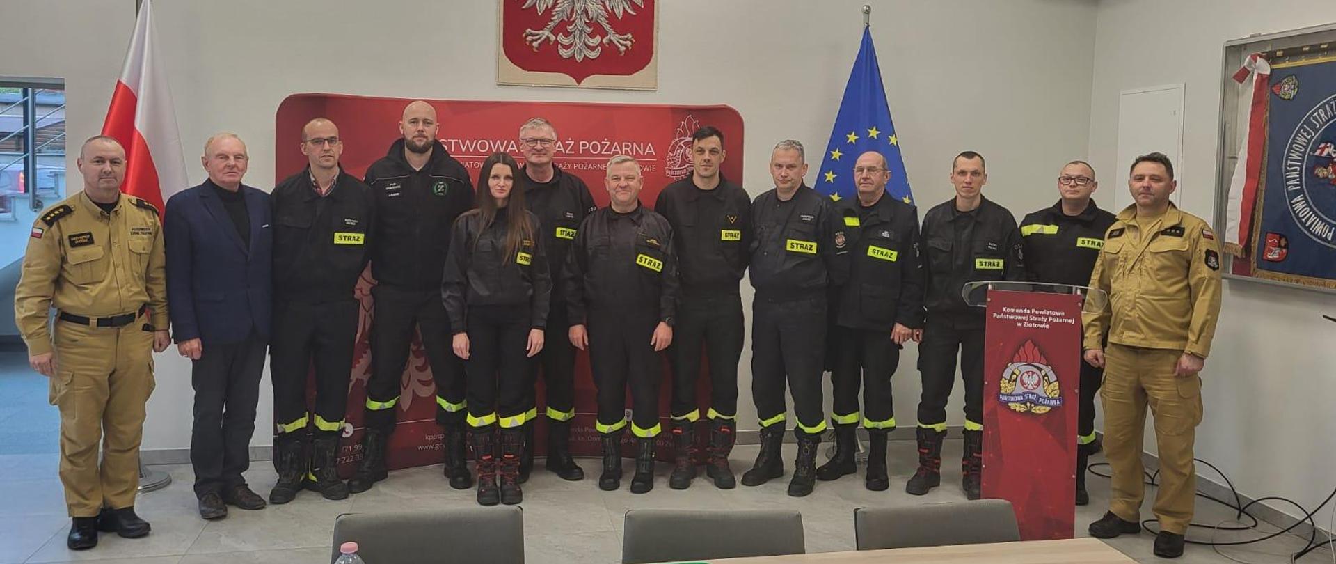 13 strażaków na zbiorowym zdjęciu po zakończeniu posiedzenia zarządu