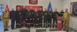13 strażaków na zbiorowym zdjęciu po zakończeniu posiedzenia zarządu