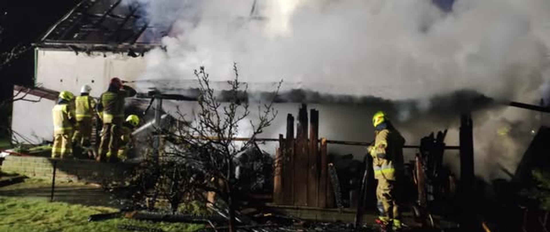 strażacy gaszący budynek