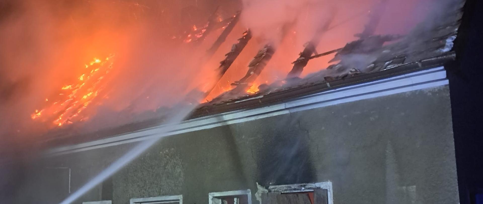 Palący się budynek z płomieniami na dachu