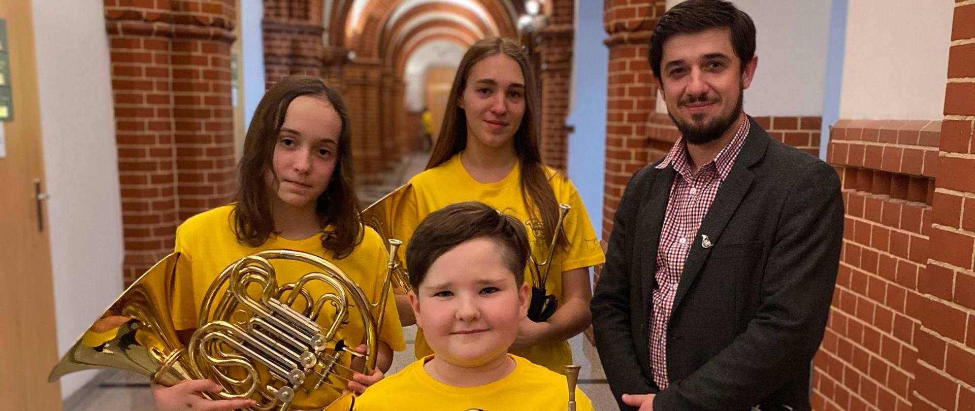 uczniowie klasy waltorni z naszej szkoły z nauczycielem Piotrem Rysiewiczem na korytarzu Akademi Muzycznej w Katowicach podczas VI Akademi Młodego Waltornisty