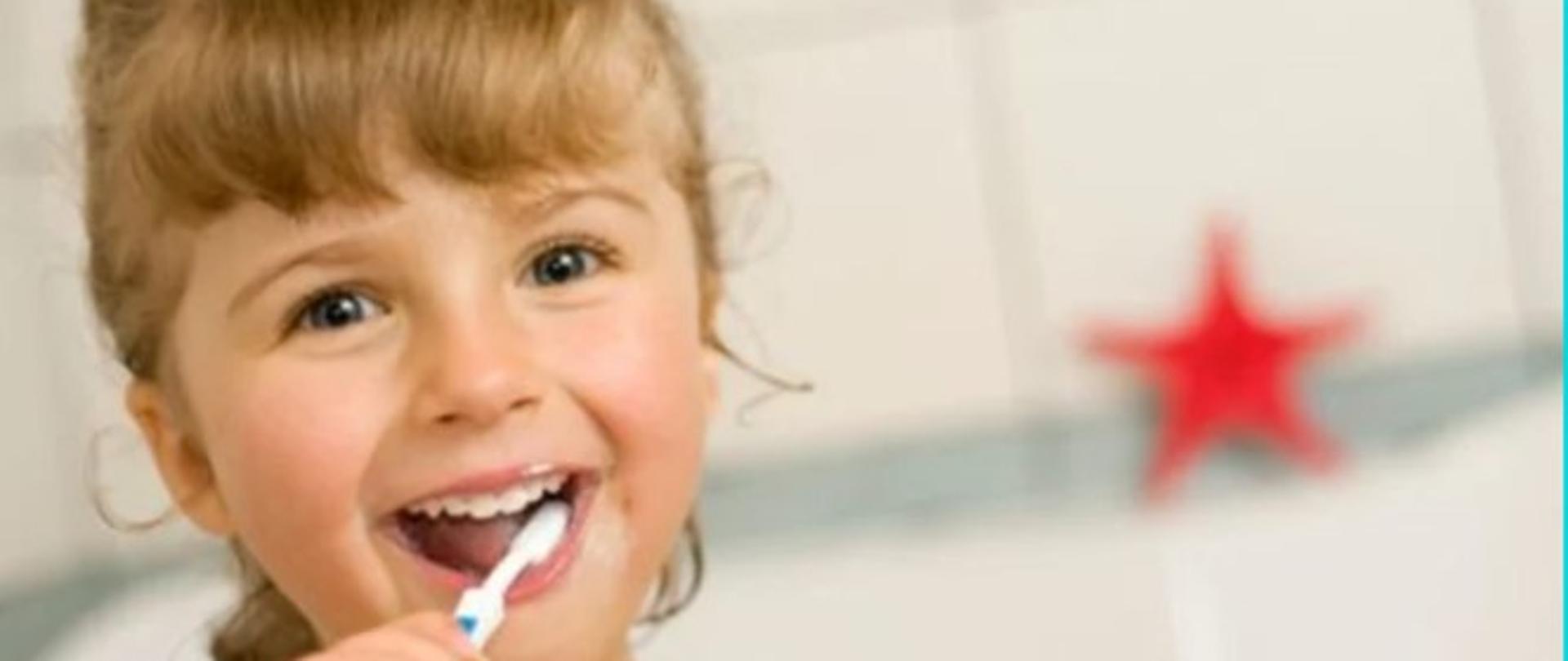 Na zdjęciu znajduje się dziewczynka w wieku przedszkolnym, która z uśmiechem myje zęby