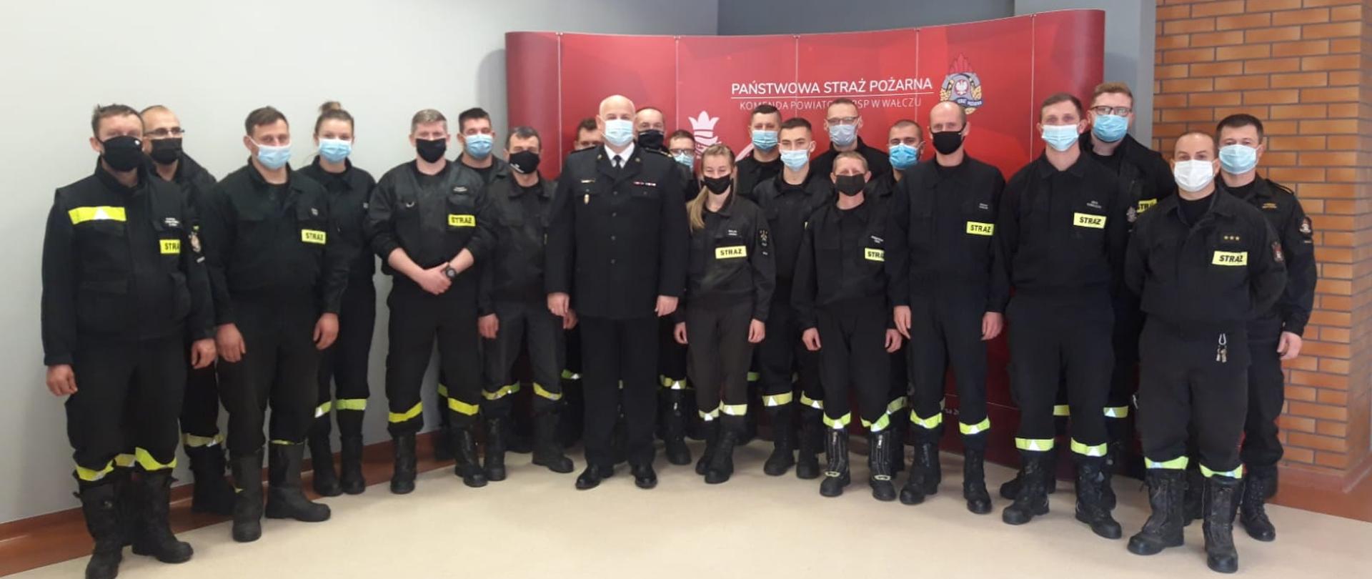 Zdjęcie przedstawia Komendanta Powiatowego, egzaminatorów i uczestników szkolenia dowódców OSP na sali konferencyjnej KP PSP w Wałczu 