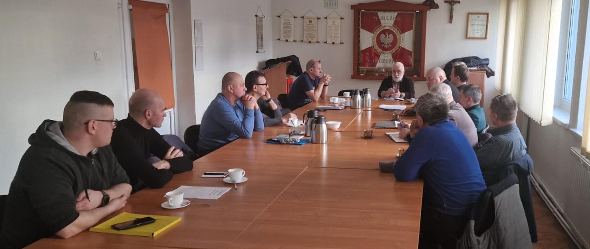 Zdjęcie przedstawia Posiedzenie Zarządu Oddziału Powiatowego Związku Ochotniczych Straty Pożarnych RP w Świdwinie, które odbywa sie w KP PSP Świdwin, uczestnicy siedzą przy stole i rozmawiają.